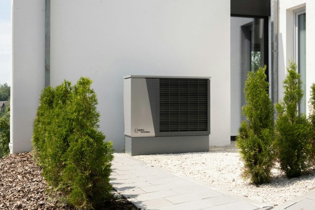pexels-photo-20046693-20046693 Outdoor air conditioner unit on a modern building surrounded by greenery and landscaping.